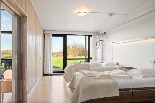 two beds in a room with white walls and windows at Musholm Holiday, Sport & Conference in Korsør