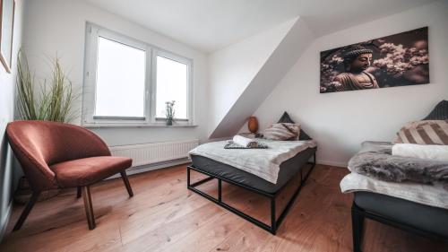 a living room with a bed and a chair at FlexHome Stilvolle Ferienwohnung in Lippstadt