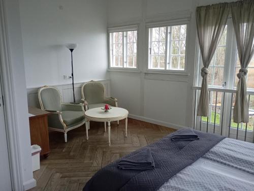 a bedroom with a bed and two chairs and a table at Stege Nor in Stege