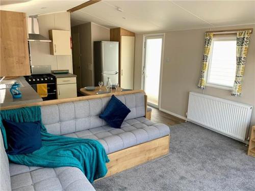 a living room with a couch and a kitchen at 3 Bedroom, 8 berth Luxury caravan in Belton