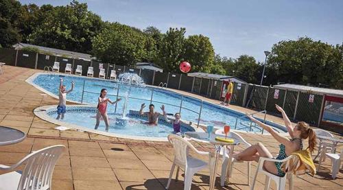 a group of people playing in a swimming pool at 3 Bedroom, 8 berth Luxury caravan in Belton