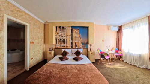 a hotel room with a large bed and a table at Бутиков хотел History in Haskovo