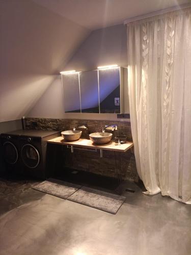 a bathroom with two sinks and a mirror at Traumhaus in der Eifel in Hellenthal