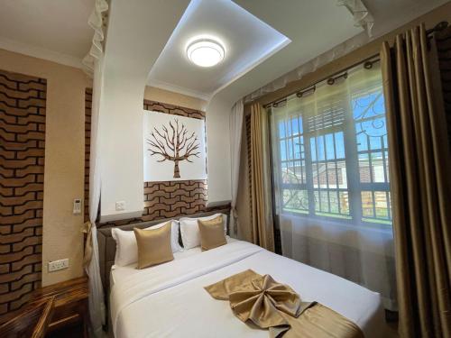 a bedroom with a bed with a bow on it at Mawimbi Jiko Hotel in Taveta
