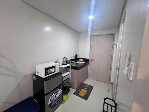 a small kitchen with a counter and a microwave at Iloilo Condo Sm City Style Residences in Iloilo City