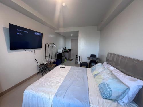 a bedroom with a bed and a flat screen tv at Iloilo Condo Sm City Style Residences in Iloilo City