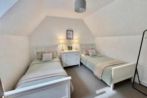 two twin beds in a room with white walls at Secret City Cottage - Peaceful - Private Garden in Aberdeen