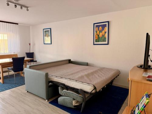a bedroom with a bed in a room with a desk at Ferienwohnung Karolus in Sinsheim