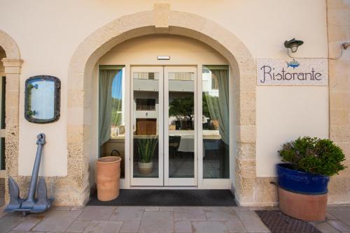 an entrance to a restaurant with a glass door at Corte Di Nettuno - CDSHotels in Otranto