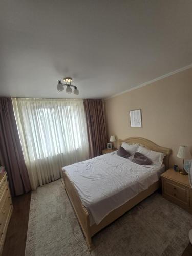 a bedroom with a large bed and a window at Casa Izabella in Tîrnăveni