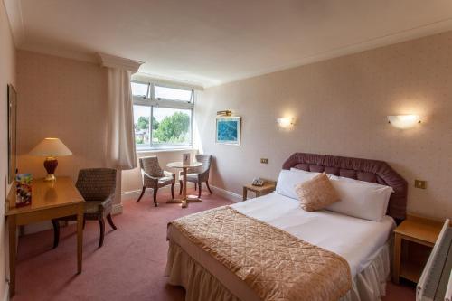 een hotelkamer met een bed en een tafel en stoelen bij Hampstead Britannia in Londen