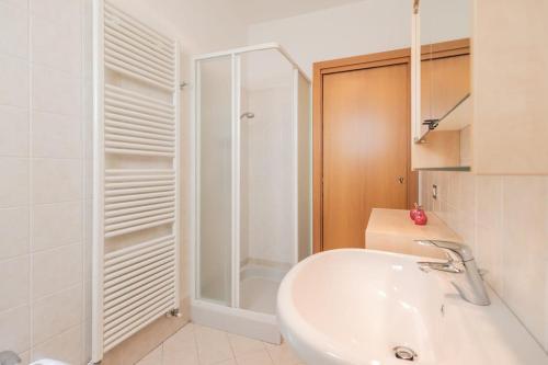 a white bathroom with a sink and a shower at Angelic Darsena Apartment in Ravenna