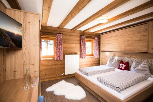 a bedroom with a bed in a wooden room at Bergchalet Rauchenhof in Reith im Alpbachtal