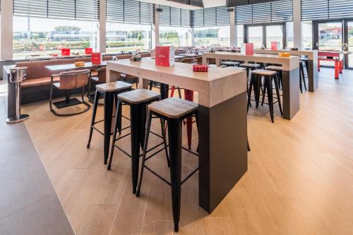 a bar in a restaurant with stools and tables at Martin's Red in Tubize