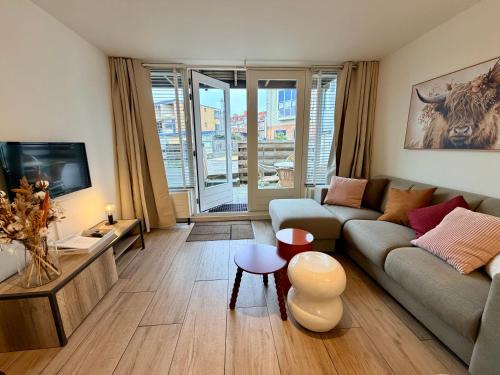 a living room with a couch and a table at SummerTime Bergen aan Zee in Bergen aan Zee