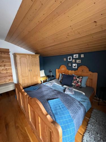 a bedroom with a wooden bed with a blue comforter at 4 Elements Appartmenthaus Monarda in Flachau