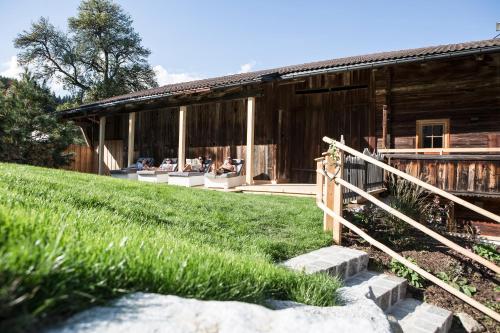 a group of people sitting on the porch of a barn at Bergchalet Rauchenhof in Reith im Alpbachtal