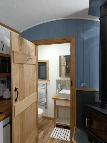 a bathroom with a wooden door and a sink at Old Quay Escape in Tenby