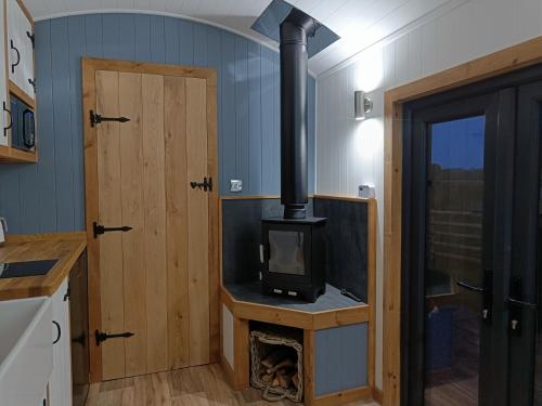 a kitchen with a stove in a tiny house at Old Quay Escape in Tenby