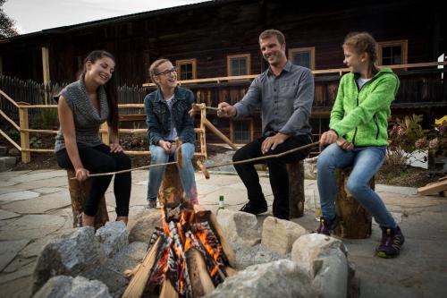 a group of people sitting around a fire at Bergchalet Rauchenhof in Reith im Alpbachtal