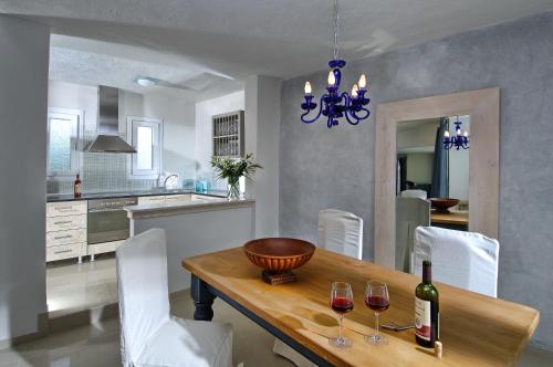 uma sala de jantar com uma mesa com copos de vinho em Paradise Island Villas em Hersonissos
