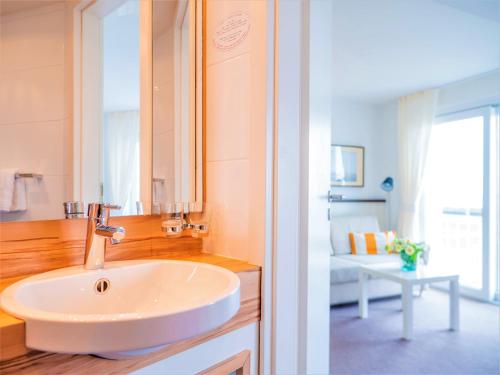 a bathroom with a white sink and a mirror at Miramar in Helgoland
