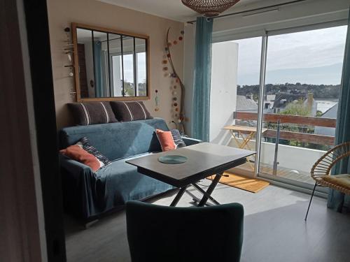 a living room with a couch and a table at les vagues a Bénodet in Bénodet