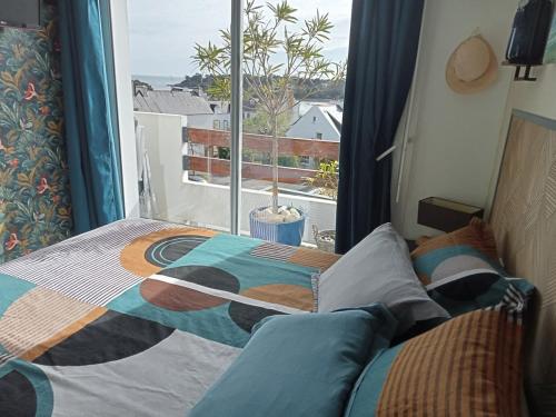 a bedroom with a bed and a window with a view at les vagues a Bénodet in Bénodet