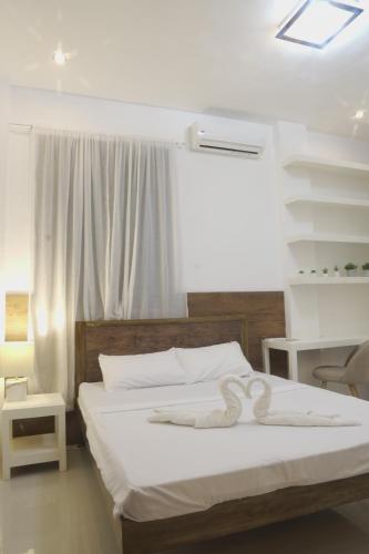 a white bed with a white towel on it at Rue DeuxVilles Villa in Loon