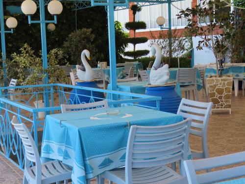 zwei Schwäne sitzen an einem Tisch in einem Restaurant in der Unterkunft Blue Sky Studios in Xiropigado
