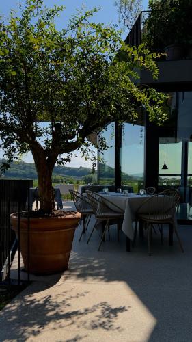 un tavolo e delle sedie con un albero in un cortile di Stilla Rooms & Contemporary Cuisine a Colognola ai Colli