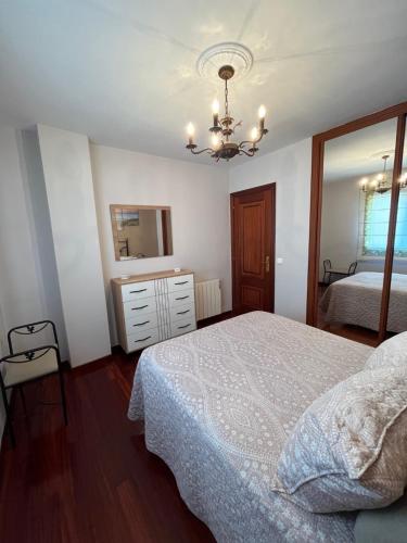 a bedroom with a bed and a dresser and a mirror at Alquiler Vacacional en Ribeira in Ribeira