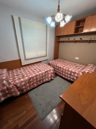 a living room with two beds and a window at Alquiler Vacacional en Ribeira in Ribeira