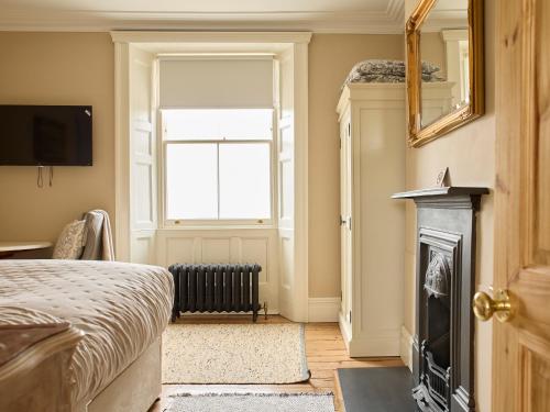 a bedroom with a bed and a fireplace and a window at The Old School House in Bristol