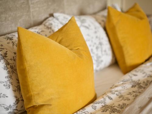 three yellow pillows sitting on a couch at The Old School House in Bristol