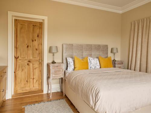 a bedroom with a large bed with yellow pillows at The Old School House in Bristol