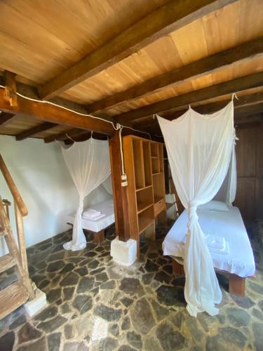a bedroom with two beds with mosquito netting at Casa Nemo Beach Resort & Spa in Sabang