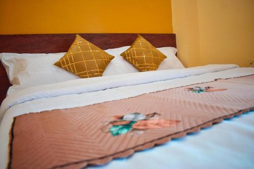 a bed with a blanket and pillows with a girl on it at Hotel Sawai View in Sawāi Mādhopur