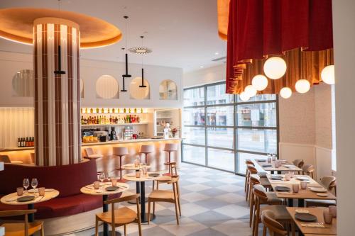 a restaurant with tables and chairs and a bar at Hotel Gran Ultonia in Girona