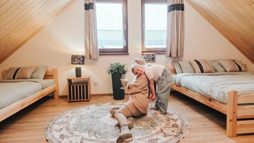 Ein Mann und eine Frau tanzen in einem Wohnzimmer. in der Unterkunft Bliżej do nieba in Istebna
