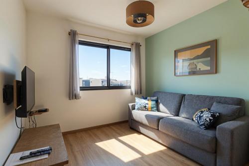a living room with a couch and a window at L'écrin de Sérénité - CNPE Bugey - Meximieux in Meximieux