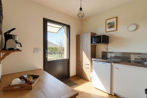 a kitchen with a table and a counter top at L'écrin de Sérénité - CNPE Bugey - Meximieux in Meximieux