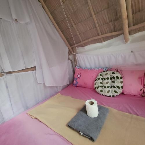 a bed in a tent with a roll of toilet paper at Island Crib in El Nido