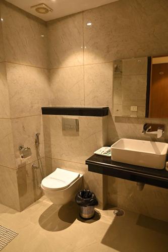 a bathroom with a toilet and a sink at Hotel Sahil Suites in Katra