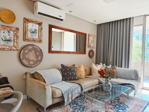 a living room with a couch and a glass table at Instellies Andringa Walk Apartment in Stellenbosch