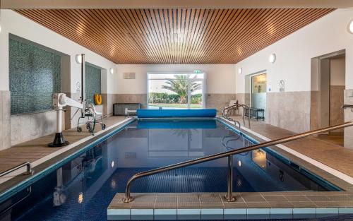 a swimming pool in a hotel room with a swimming poolvisorvisor at Maison des Landes - Accessible Hotel in St. Ouen's