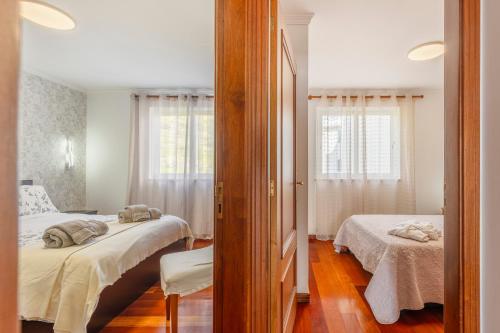 a bedroom with two beds and a mirror at BoLina Ocean View in Caniço