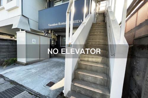 a set of stairs in a building with a no elevator sign at Vacation Rental NISHIDA in Kagoshima