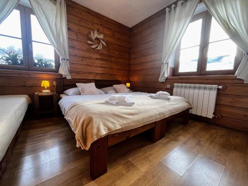 a bedroom with a bed in a room with windows at Vila Panorama in Ždiar