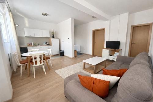 a living room with a couch and a table and a kitchen at Apartmani Sun & Moon in Žepče